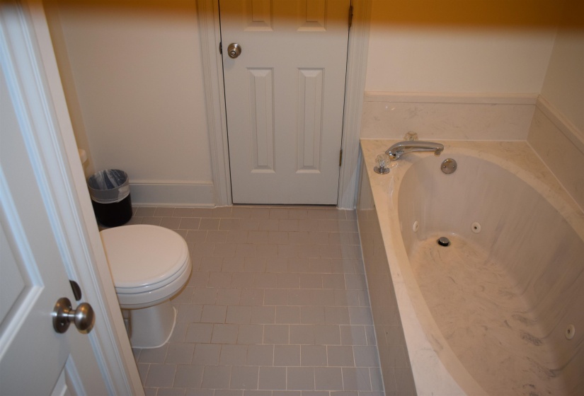 Bathroom featuring toilet, a bath, and tile patterned floors