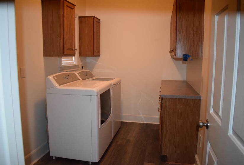 Laundry area with cabinets, washing machine and dryer, and dark wood-type flooring