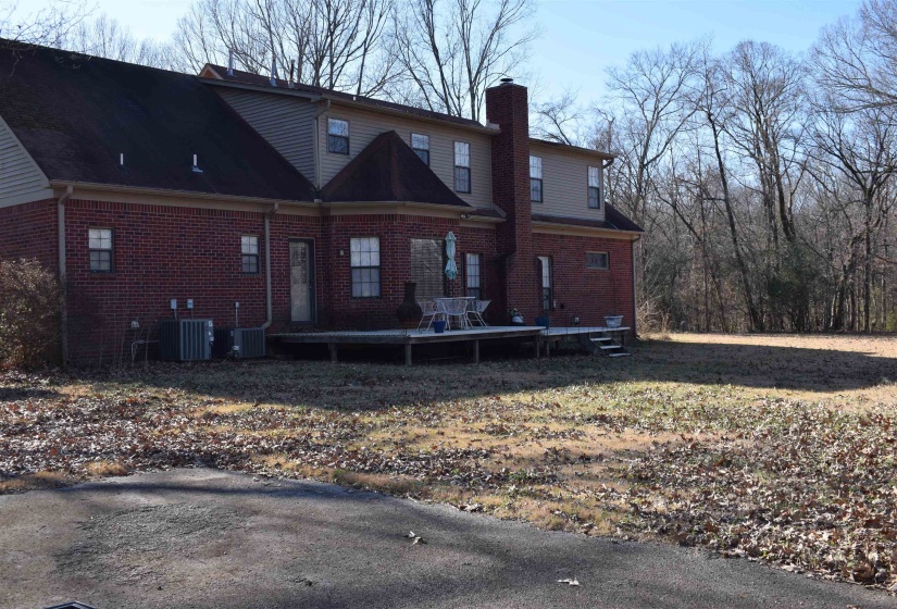 Back of house with cooling unit and a deck