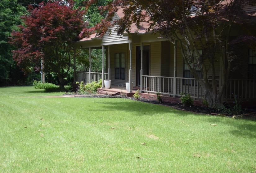 View of front of home featuring covered porch and a front lawn