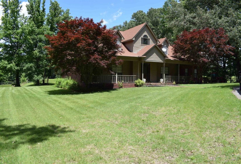 View of front of property featuring covered porch and a front yard
