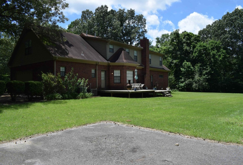 View of front of property with a chimney, brick siding, and a front yard