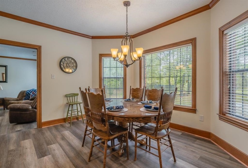 Dining area featuring a chandelier, a textured ceiling, hardwood / wood-style flooring, and ornamental molding