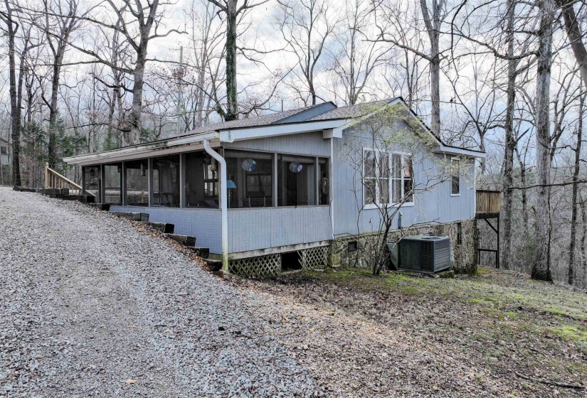 View of property exterior with a sunroom and central AC unit