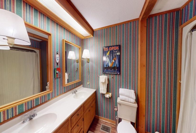 Bathroom featuring a textured ceiling, vanity, ceiling fan, hardwood / wood-style floors, and toilet