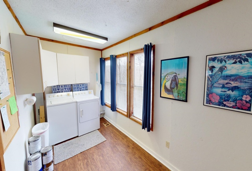 Washroom featuring cabinets, crown molding, washer and dryer, a textured ceiling, and dark hardwood / wood-style flooring