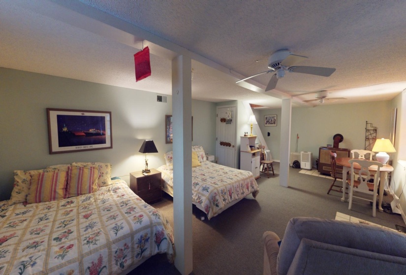 Carpeted bedroom with ceiling fan and a textured ceiling