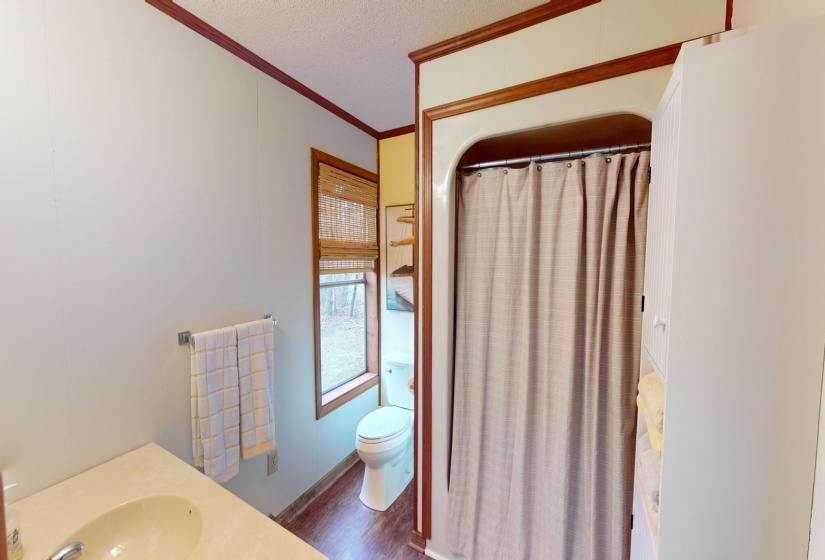 Bathroom with sink, crown molding, hardwood / wood-style floors, a textured ceiling, and toilet