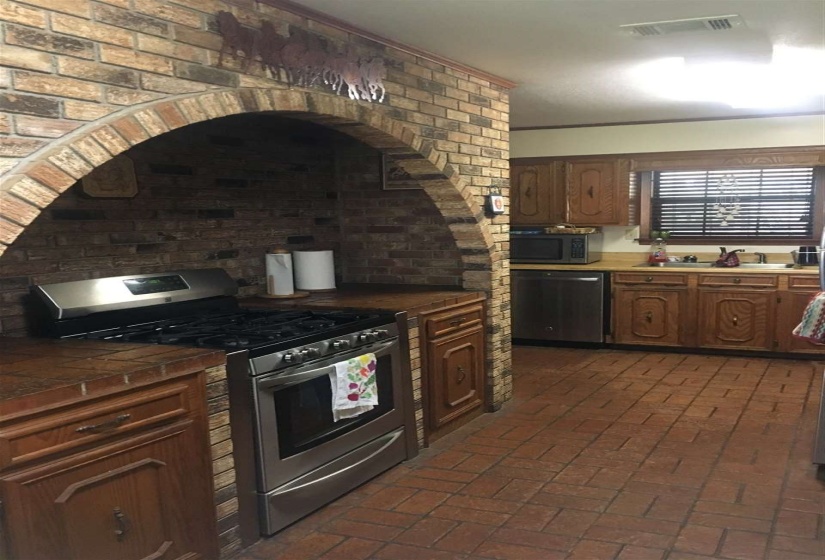 Unique brick arch and counter tops around gas stove.  Brick floors