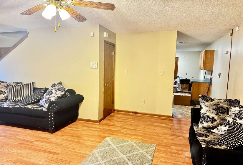 Living room featuring ceiling fan, light hardwood / wood-style flooring, and a textured ceiling