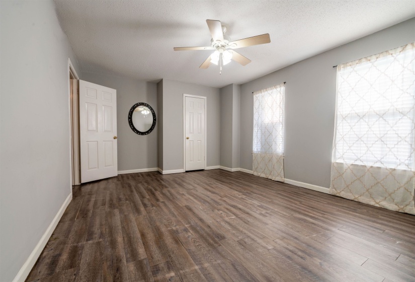 Unfurnished bedroom with ceiling fan, dark hardwood / wood-style floors, and a textured ceiling