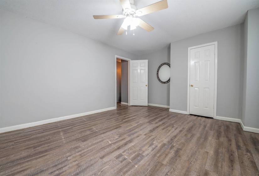 Unfurnished bedroom with ceiling fan and dark hardwood / wood-style flooring