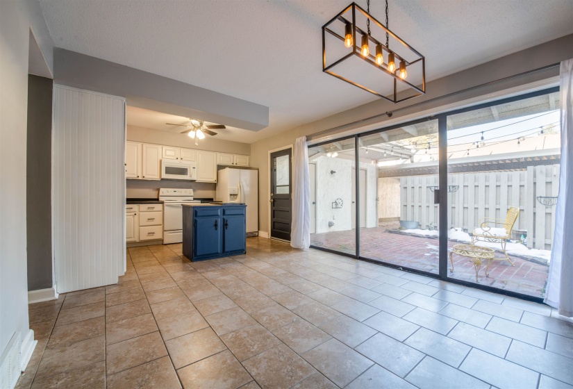 Kitchen featuring pendant lighting, white appliances, ceiling fan, light tile patterned floors, and white cabinetry