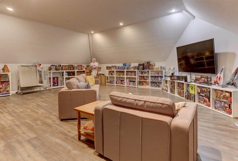 Recreation room with lofted ceiling, wood finished floors, and recessed lighting