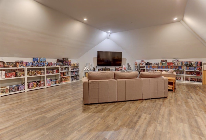 Living room featuring wood finished floors, lofted ceiling, and recessed lighting