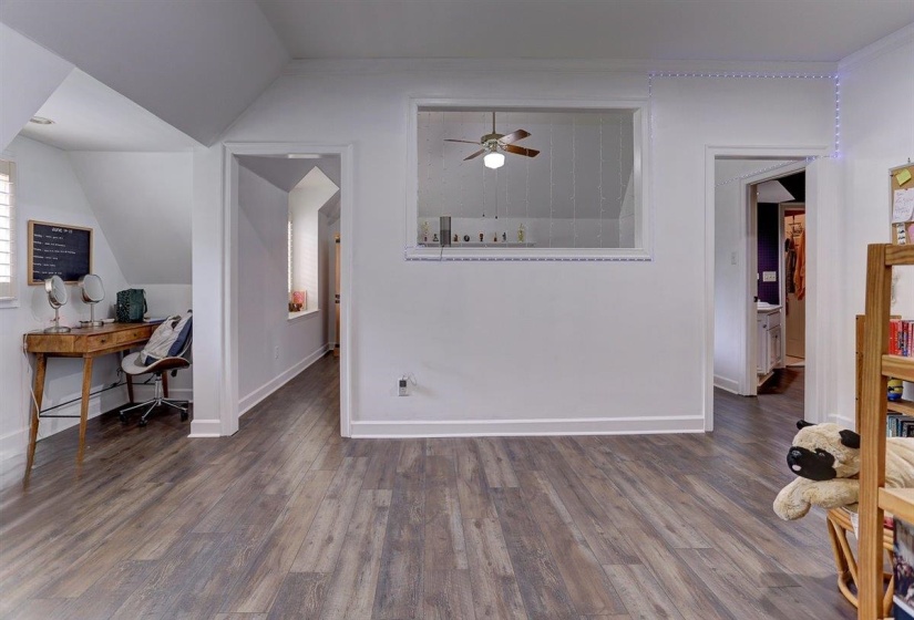 Interior space featuring baseboards, wood finished floors, and vaulted ceiling