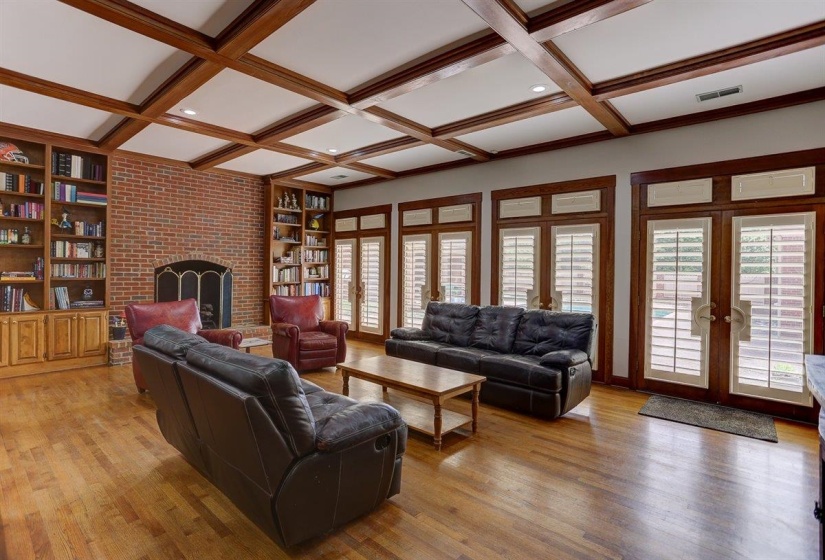 Living area featuring french doors, visible vents, a fireplace, beam ceiling, and light wood finished floors