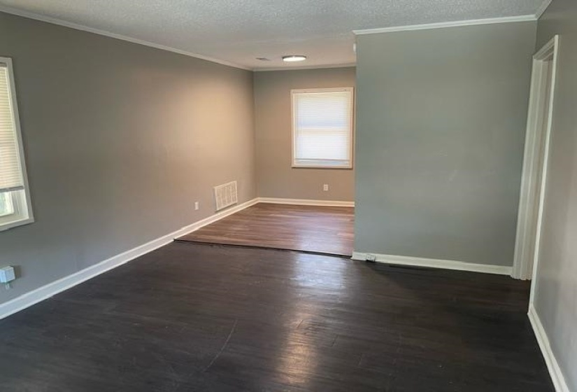 Spare room featuring ornamental molding, a textured ceiling, and dark hardwood / wood-style flooring