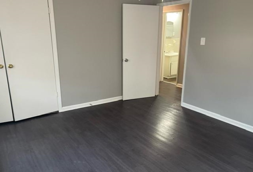 Unfurnished bedroom featuring a closet and dark hardwood / wood-style flooring