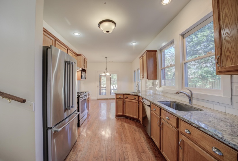 Kitchen with decorative backsplash, hanging light fixtures, high quality appliances, and sink