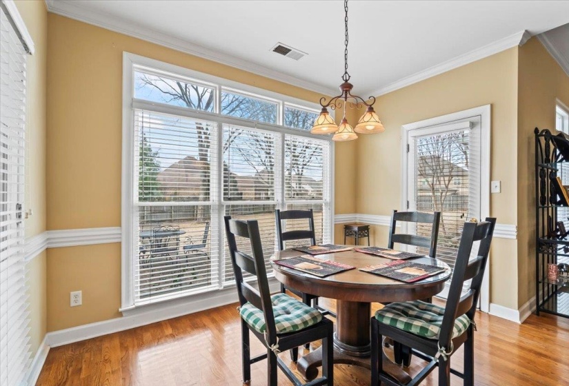 Dining area featuring light hardwood / wood-style floors, ornamental molding, and a notable chandelier