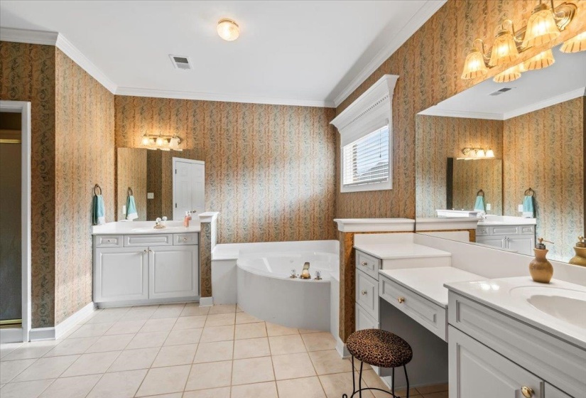 Bathroom featuring a tub, vanity, ornamental molding, and tile patterned flooring