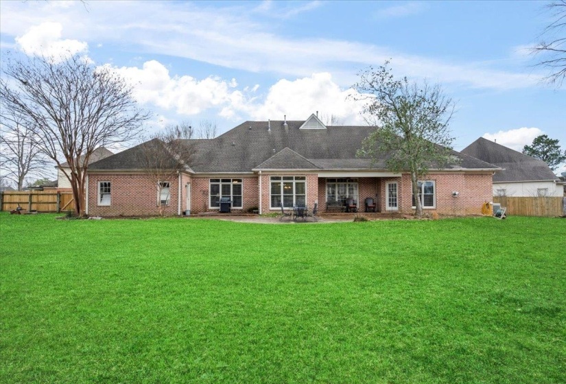 Rear view of house featuring a patio area and a yard