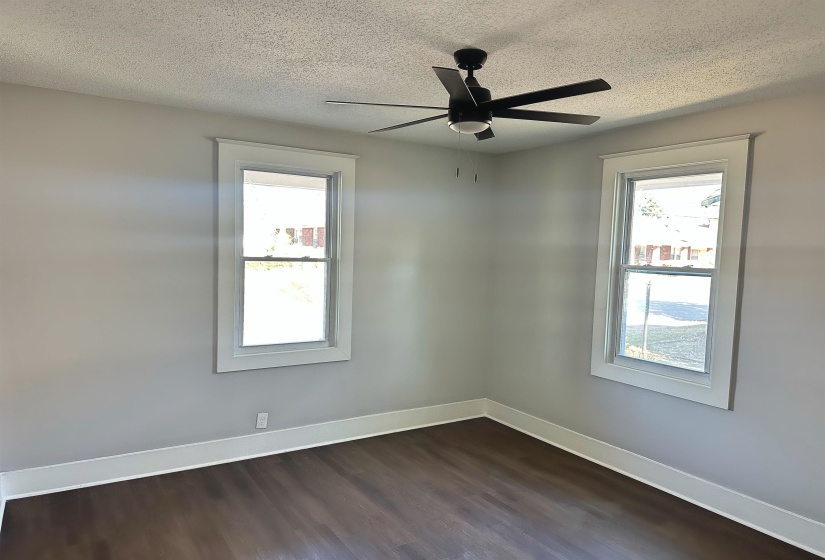 Unfurnished room with ceiling fan, dark hardwood / wood-style floors, and a textured ceiling