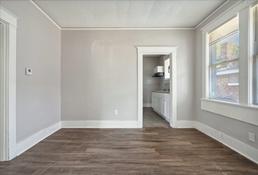 Unfurnished room with dark hardwood / wood-style flooring, a wealth of natural light, ornamental molding, and a textured ceiling