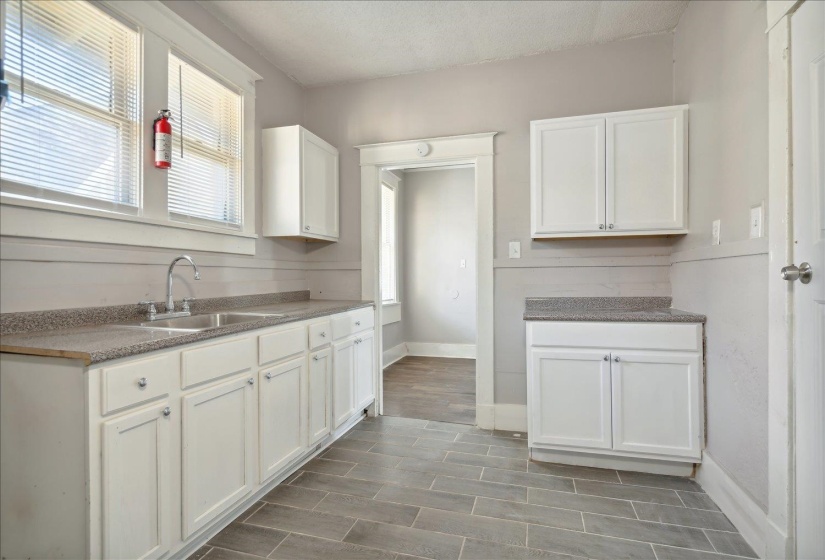 Kitchen featuring sink, white cabinetry, and a textured ceiling