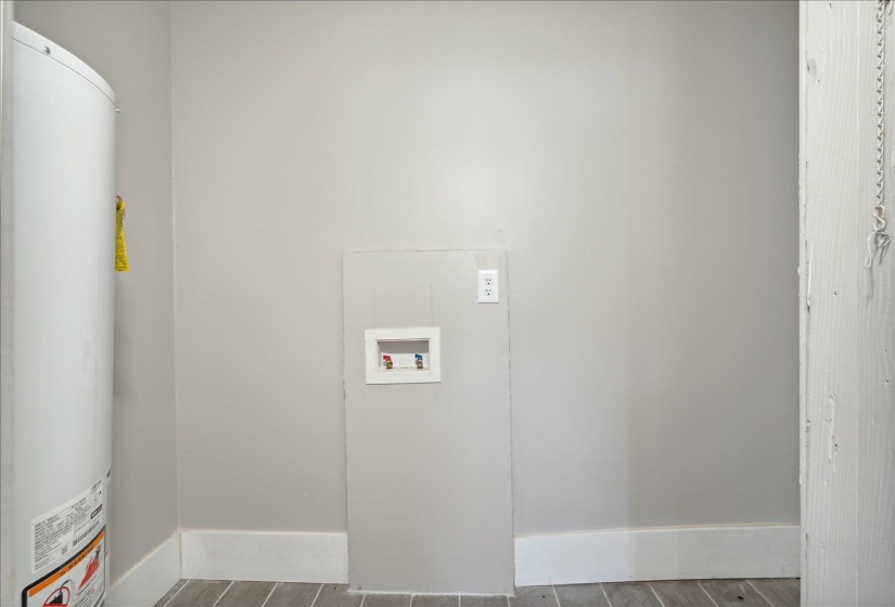 Clothes washing area featuring water heater and washer hookup