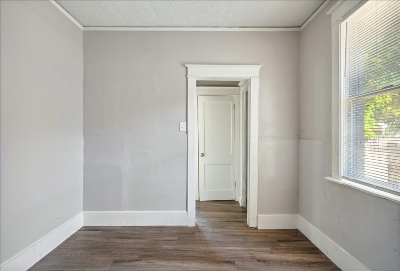 Empty room featuring a textured ceiling, dark hardwood / wood-style floors, and crown molding