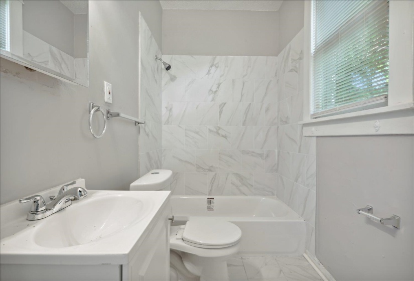 Full bathroom featuring toilet, vanity, and tiled shower / bath