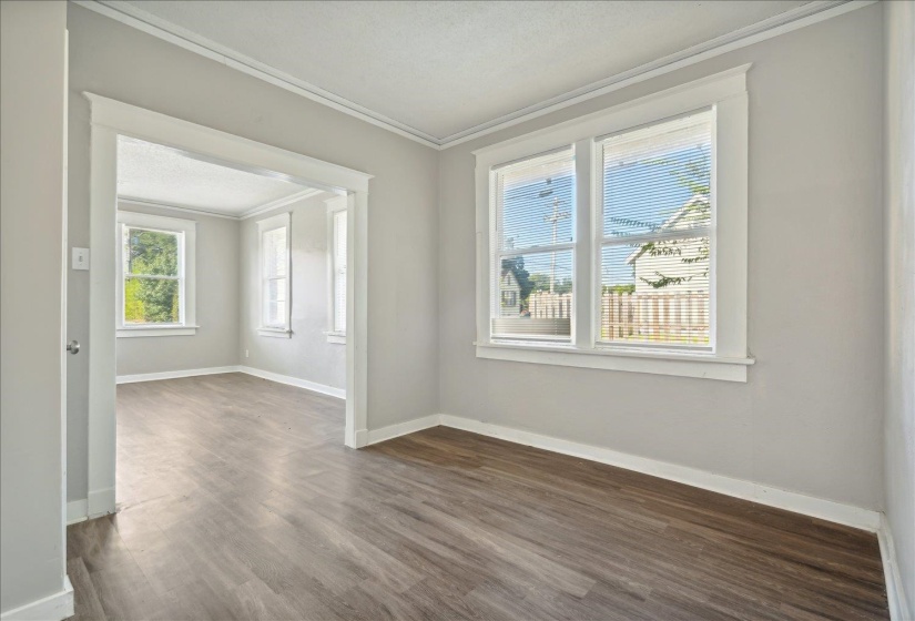 Empty room featuring dark wood-type flooring, a textured ceiling, and ornamental molding