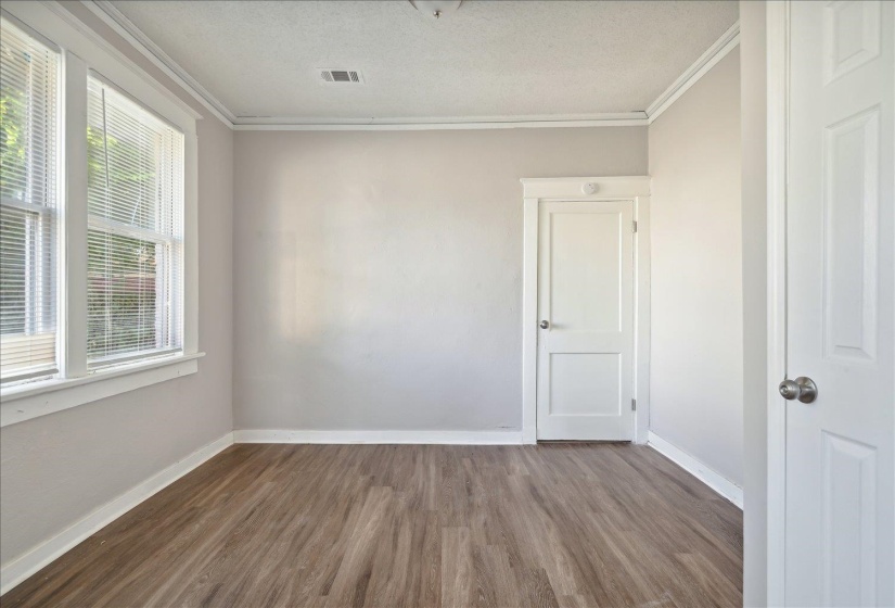 Unfurnished room featuring a textured ceiling, ornamental molding, and hardwood / wood-style floors