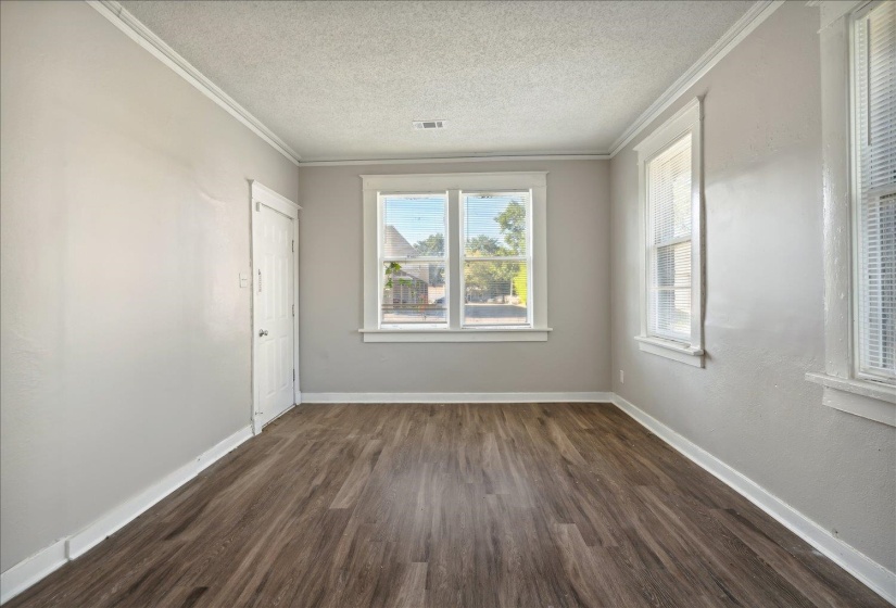 Unfurnished room with a textured ceiling, ornamental molding, and dark hardwood / wood-style floors