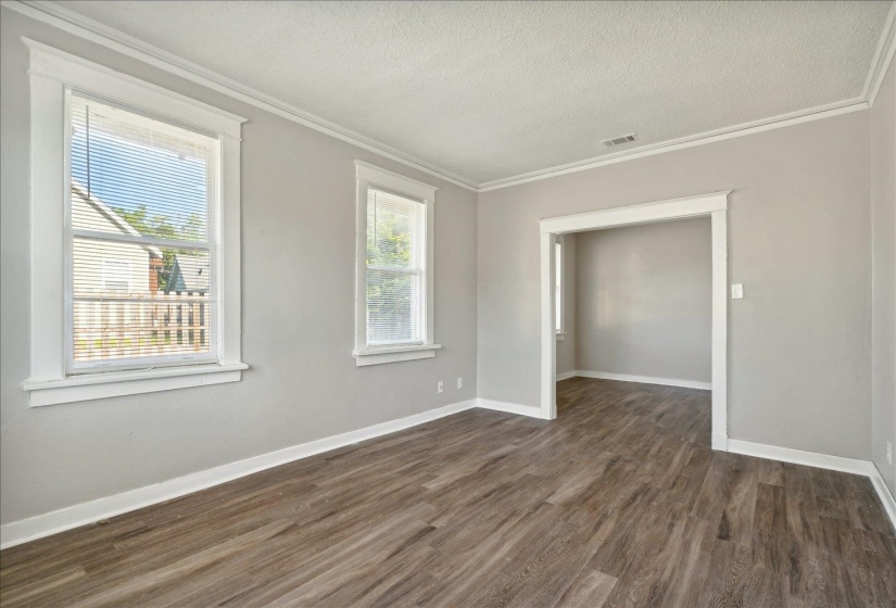 Spare room with dark hardwood / wood-style floors, crown molding, and a textured ceiling