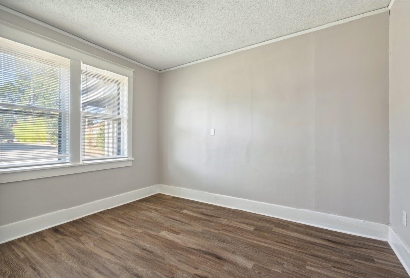 Unfurnished room featuring a textured ceiling, dark hardwood / wood-style floors, and crown molding