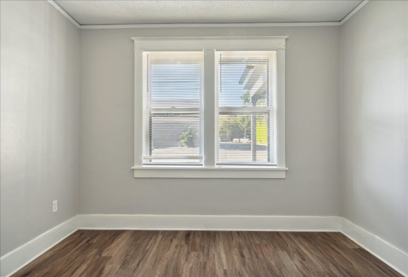 Empty room featuring crown molding and dark hardwood / wood-style floors