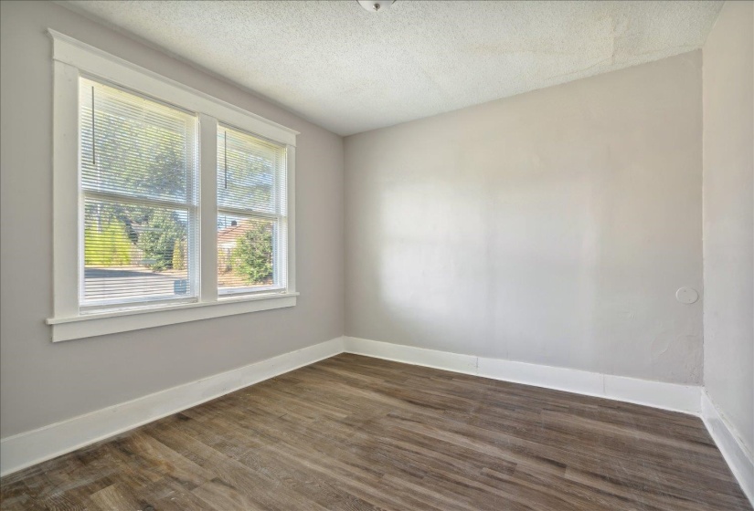 Empty room featuring dark wood-type flooring and a textured ceiling