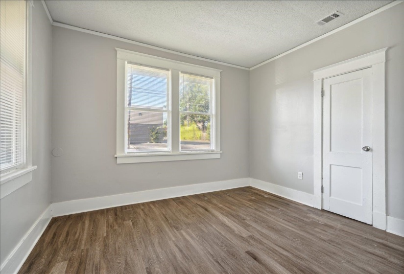 Unfurnished room with dark wood-type flooring, ornamental molding, and a textured ceiling