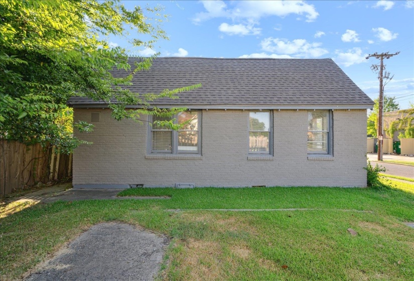 View of side of property with a lawn