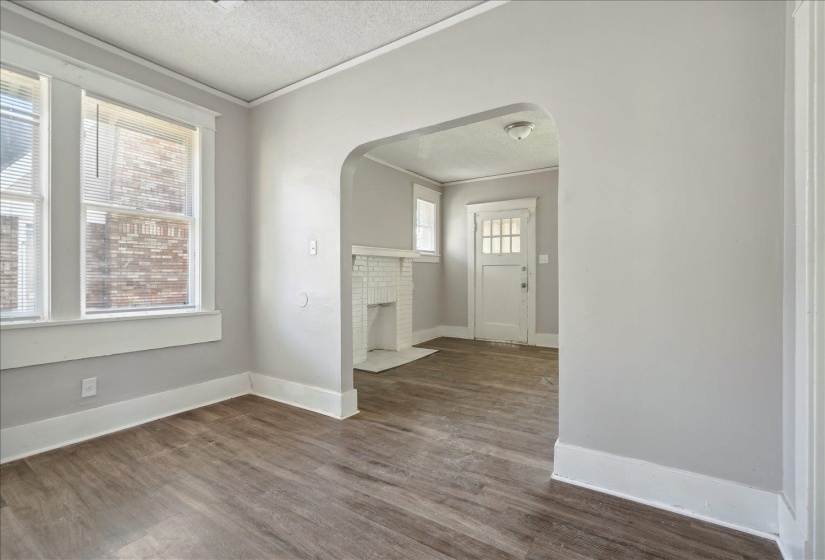 Foyer entrance with hardwood / wood-style flooring, plenty of natural light, a textured ceiling, and crown molding