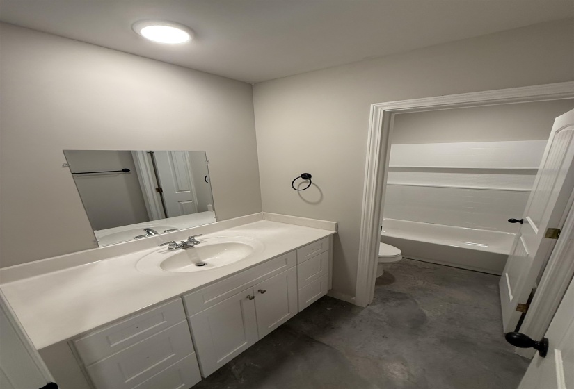 Bathroom featuring vanity, concrete floors, and toilet