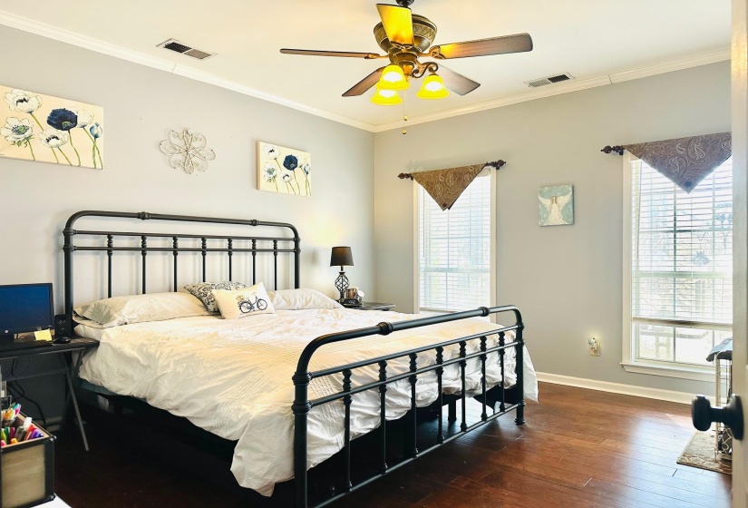 Bedroom featuring ceiling fan, dark hardwood / wood-style flooring, and ornamental molding