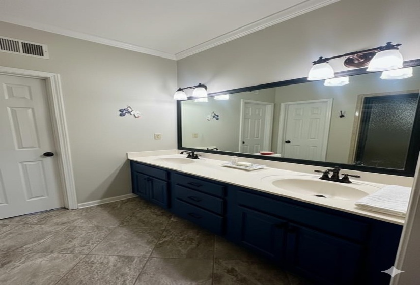 Full bath featuring double vanity and crown molding