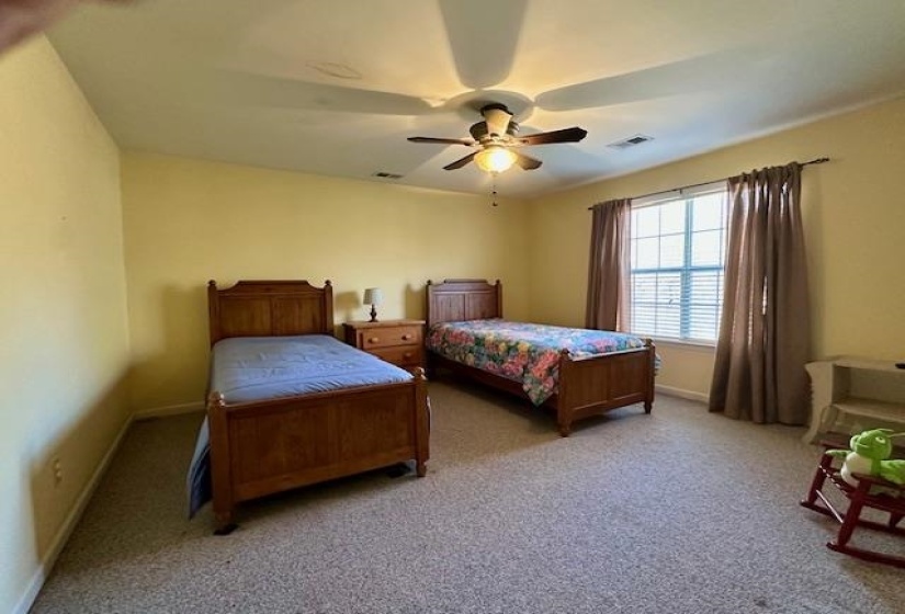 Carpeted bedroom with baseboards and a ceiling fan