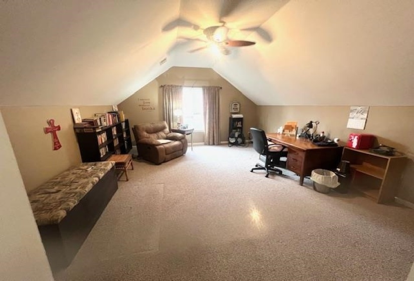 Home office featuring lofted ceiling, a ceiling fan, and carpet floors