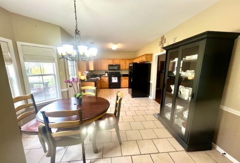 Dining room featuring light tile patterned flooring, baseboards, and a chandelier
