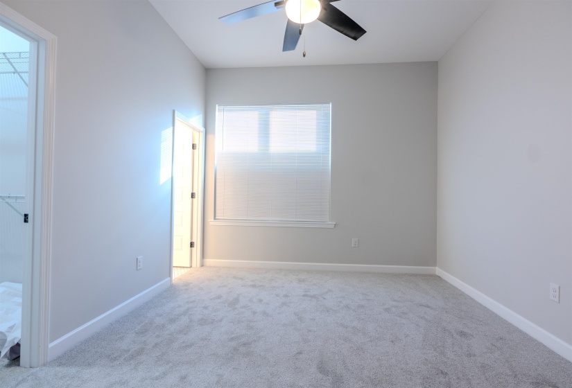 Carpeted empty room featuring ceiling fan